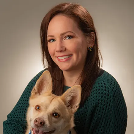 Melissa Mazur holding a dog with a bandana